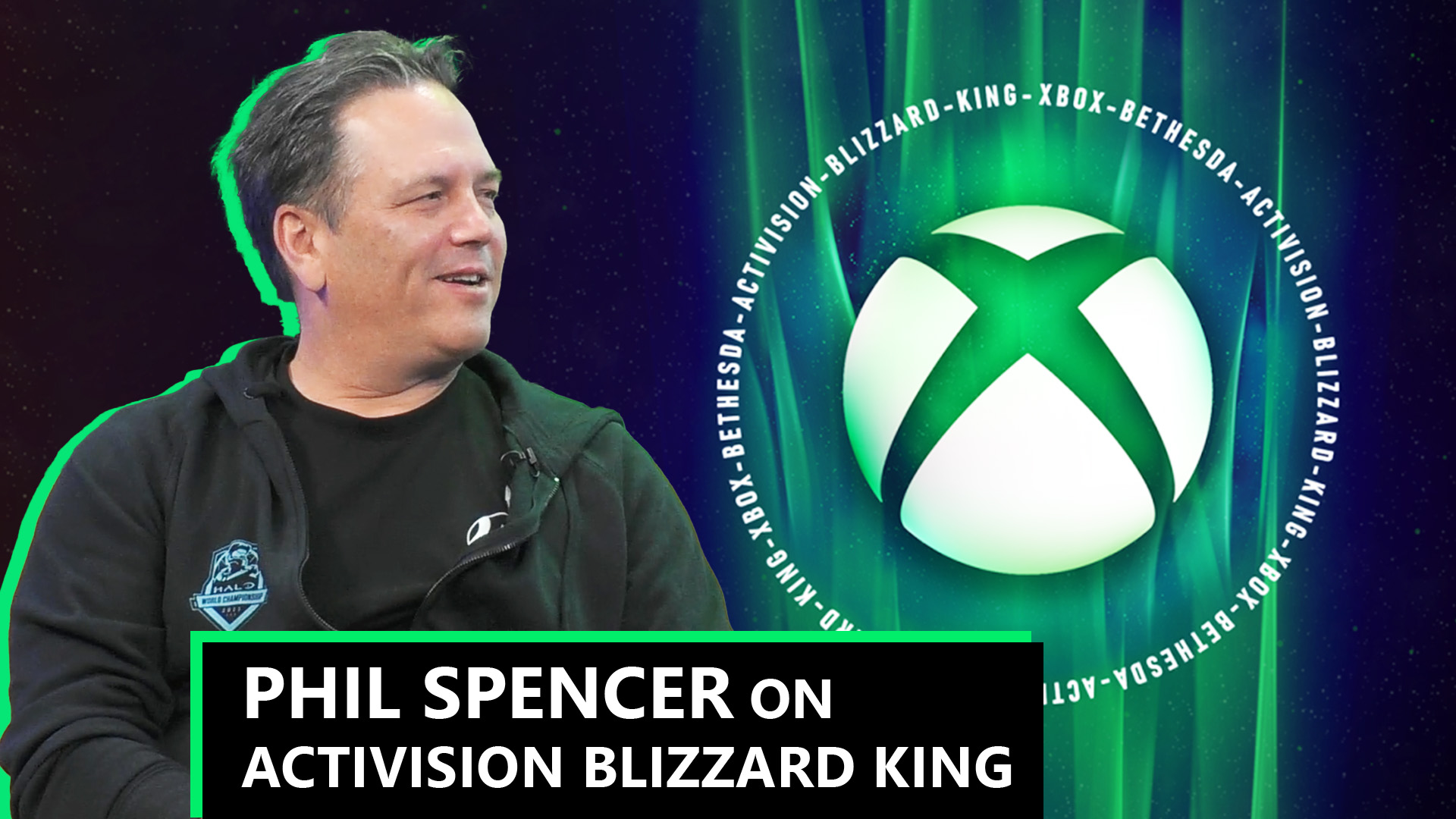 Phil Spencer looking at the Xbox logo with Activision, Blizzard, King text circling around.