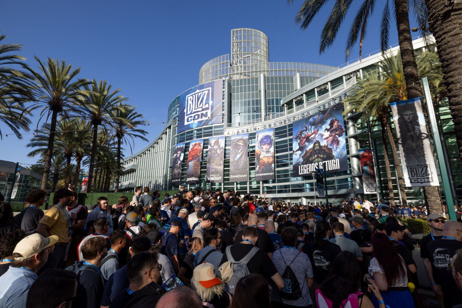 Crowds of attendees outside the Anaheim Convention Center, hung with BlizzCon banners for Diablo, World of Warcraft, StarCraft and Overwatch
