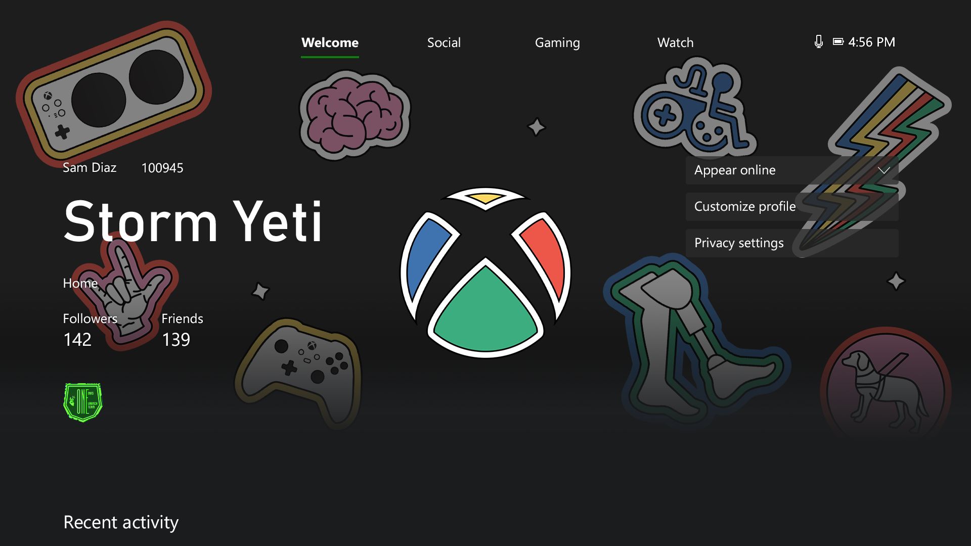 Ein Xbox-Konsolenprofil mit der rot, grün, blau und gelb eingefärbten Sphäre für den Disability Pride Month und dem ergänzenden Profilthema, das die folgenden Symbole zeigt: den Xbox Adaptive Controller, ein Gehirn, das amerikanische Gebärdensprachzeichen für "Ich liebe dich", einen Blitz, einen Rollstuhl, einen Blindenhund, Beinprothesen sowie den originalen Xbox Controller.