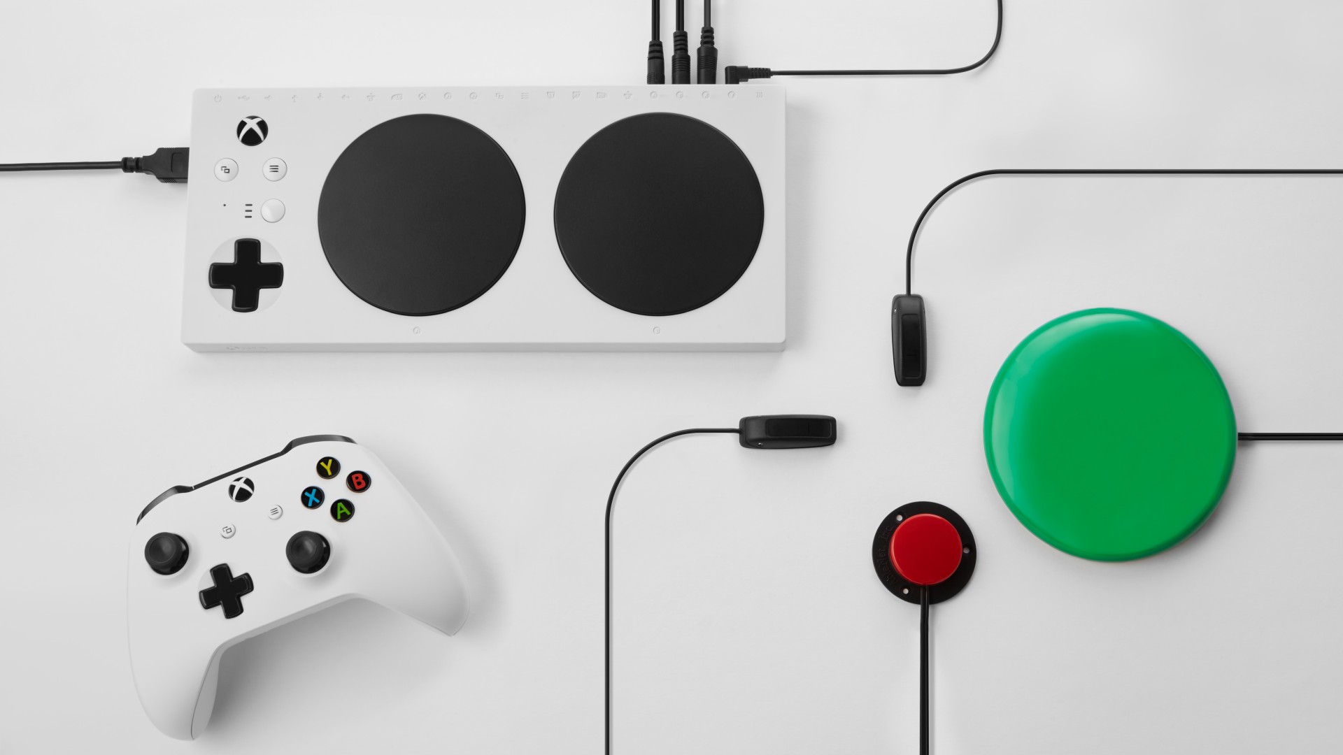 Imagem de uma configuração do Xbox Adaptive Controller, completa com um controle e outras saídas.