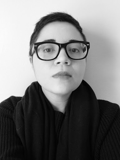 Imagem de perfil da artista Danielle Taphanel usando uma blusa preta e óculos de armação preta