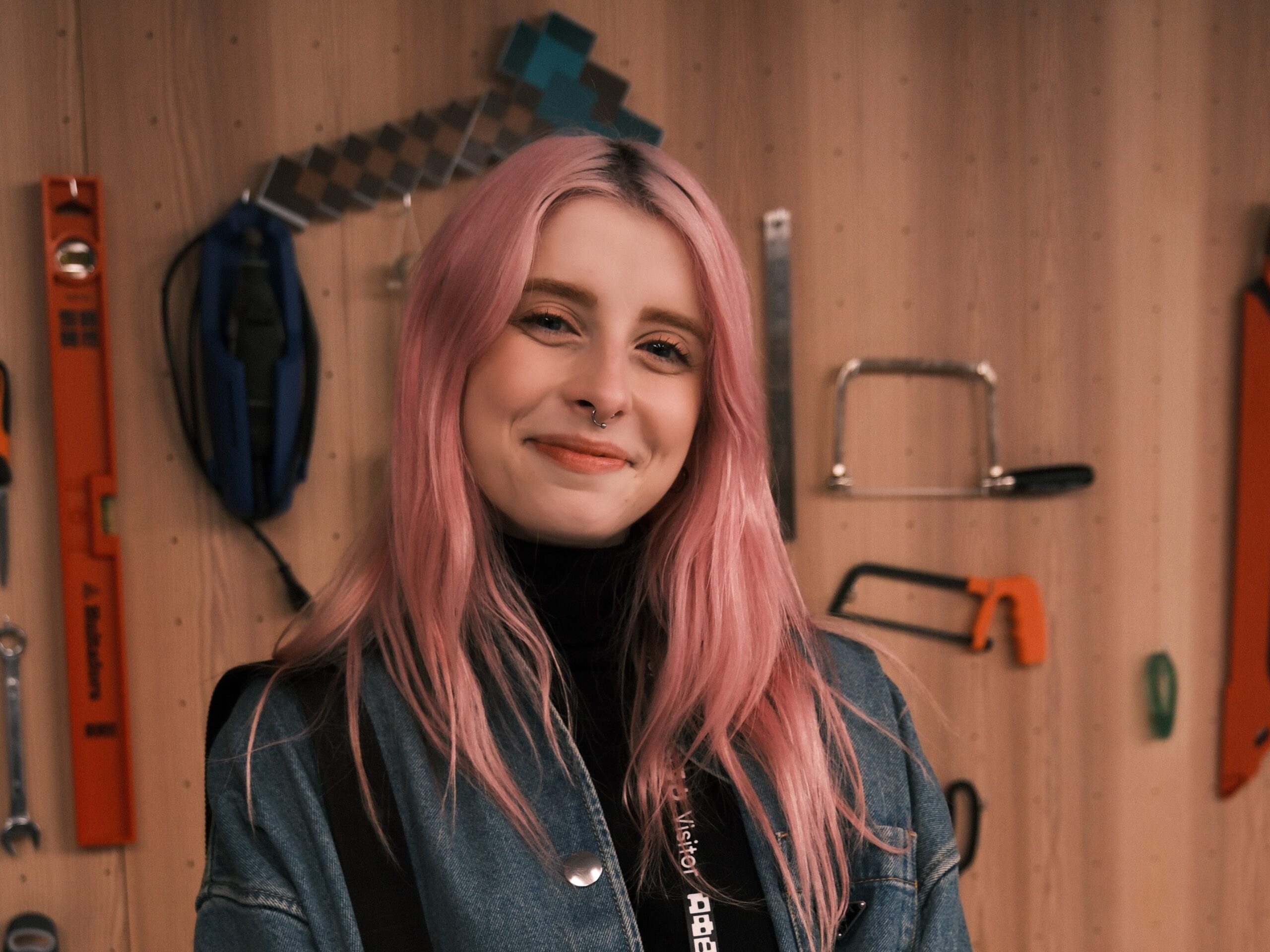 Imagem da criadora de conteúdo Bagi, uma mulher de pele clara, cabelo colorido e vestindo roupa preta